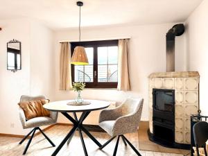 a living room with a table and chairs and a stove at Studio Lake View Faulensee in Faulensee +31 photos