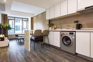 a kitchen with a washing machine and a table at ROLA&RICCI Hotel Chengdu East Branch in Chengdu