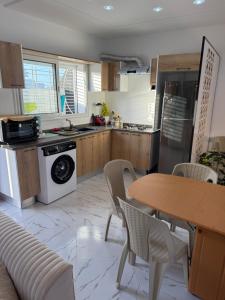 a kitchen with a table and chairs and a stove at Villa alnaser in Awlād ‘Umar