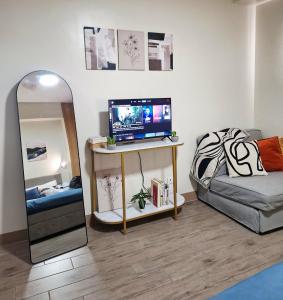 a room with a mirror and a television on a table at Studio 7C at One Regis in Bacolod