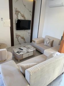 a living room with two couches and a tv at Villa alnaser in Awlād ‘Umar