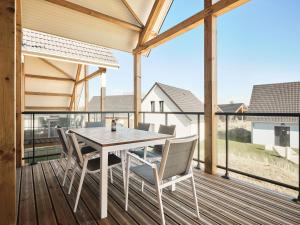 a dining room with a table and chairs on a deck at Dormio Resort Berck-sur-Mer in Berck-sur-Mer
