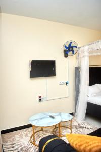 a living room with two tables and a bed at Deluxe Homes 2, Voi in Voi