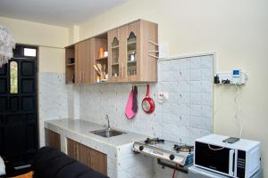 a small kitchen with a sink and a microwave at Deluxe Homes 2, Voi in Voi