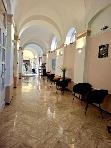 a hallway with tables and chairs in a building at Palazzo Cappuccini Art Relais in Naples