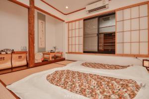 a large bed in a room with a large window at Chiangrai Ryokan in Ban Long Khi Na