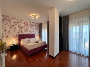 a bedroom with a bed with a floral wallpaper at Appartamento Rosa in Gualdo Tadino