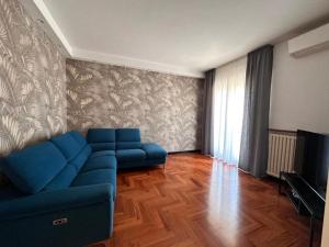 a living room with a blue couch and a television at Appartamento Rosa in Gualdo Tadino