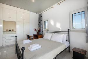 a bedroom with a bed with two towels on it at Esperado Gardens Maleme in Maleme