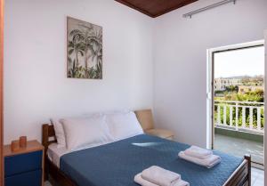 a bedroom with a bed and a balcony at Esperado Gardens Maleme in Maleme