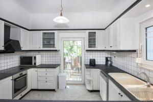 a kitchen with white cabinets and black counter tops at Esperado Gardens Maleme in Maleme
