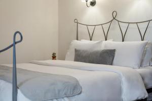 a bedroom with two beds with white sheets and pillows at Archontiko Papoutsi Pelion in Mouresi +45 photos