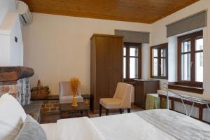 a bedroom with a bed and a desk and a chair at Archontiko Papoutsi Pelion in Mouresi