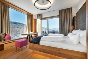 a bedroom with a large bed and a large window at Resort Hotel Bodenmais in Bodenmais +24 photos