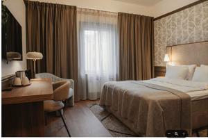 a hotel room with a bed and a desk and a window at Home Hotel Amanda in Haugesund +5 photos
