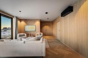 a living room with a white couch and a large window at New designer cabin in Lofoten in Storøya