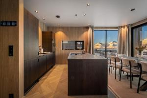 a kitchen with a counter and a table with chairs at New designer cabin in Lofoten in Storøya