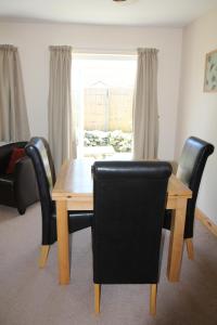 a dining room with a table and chairs and a window at Briquet Cottages, Guernsey,Channel Islands in St Saviour Guernsey