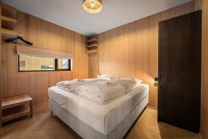 a bedroom with a large bed with wooden walls at New designer cabin in Lofoten in Storøya