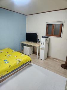 a bedroom with a bed and a desk with a computer at Chenal Motel in Daegu