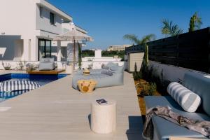 a patio with a couch and an umbrella on a house at Nesea Seaside Luxury Escape in Protaras