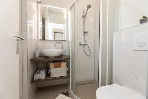 a white bathroom with a sink and a shower at Apartman Gržetić in Šilo +93 photos