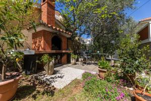 a backyard with a brick fireplace and a patio at Apartman Gržetić in Šilo