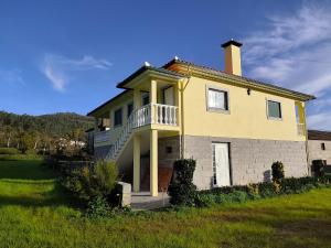a yellow house with a porch and a balcony at Casa do Reguengo in Arouca