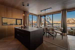 a kitchen and dining room with a view of the mountains at Secluded Lodge - Stunning Views! in Storøya