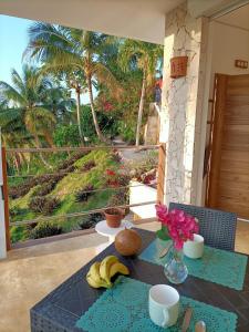 a table with bananas and flowers on a balcony at Apartment Mariquita in Las Terrenas