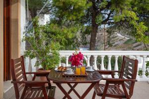 a wooden table and chairs on a porch at Irene Studios Patmos in Skala