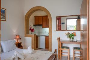 a room with a bed and a table and a kitchen at Irene Studios Patmos in Skala