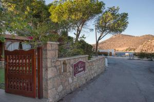 a gate on a stone wall next to a street at Irene Studios Patmos in Skala +35 photos