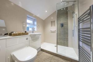 a white bathroom with a shower and a toilet at Hatchet Pond Cottage in Beaulieu +44 photos