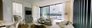 a living room with white furniture and a large window at Nesea Seaside Luxury Escape in Protaras
