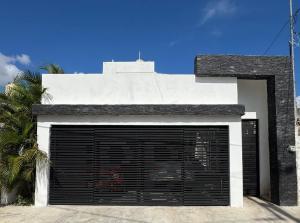 a white building with a garage door and a palm tree at Serenity Elegance Suite PB in Mérida