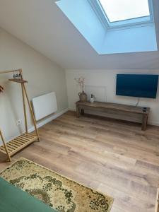 a living room with a flat screen tv and a couch at L Entre Deux Époques in Pré-en-Pail