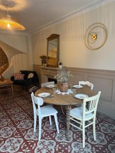 a dining table and chairs in a living room at L Entre Deux Époques in Pré-en-Pail
