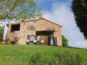 an old stone house on a green field at Agriturismo La Creta in Montepulciano