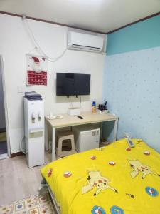 a bedroom with a bed and a desk and a computer at Chenal Motel in Daegu
