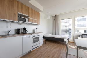 a kitchen with a bed in a room at Spot Apartments Oulu in Oulu