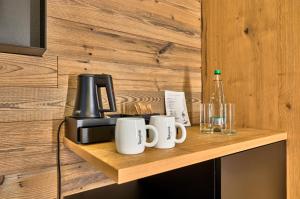 a counter with cups and a coffee maker on it at Resort Hotel Bodenmais in Bodenmais
