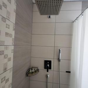 a bathroom with a shower with a phone and a wall at Grüne Sonne Refugium in Göppingen +10 photos