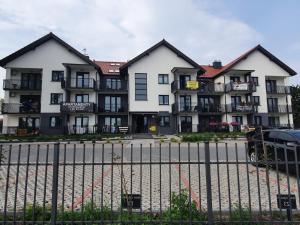 a building with a fence in front of it at Apartament Muszelka 28 in Łeba