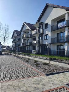 a large apartment building with a cobblestone street at Apartament Muszelka 28 in Łeba