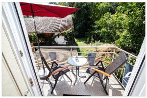 a balcony with a table and chairs and an umbrella at Haus Petra in Gleishorbach