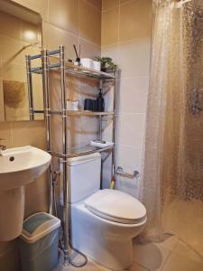 a bathroom with a toilet and a sink and a shower at Studio 7C at One Regis in Bacolod +7 photos