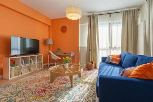 a living room with a blue couch and a tv at GreenVista 20 minutes by Therme & Airport in Voluntari