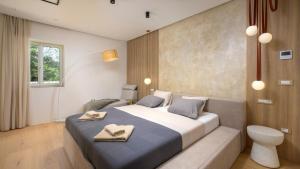 a bedroom with a large bed with two towels on it at Villa Corsa by Villas Guide in Barban +33 photos