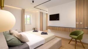 a bedroom with a bed and a chair and a television at Villa Corsa by Villas Guide in Barban